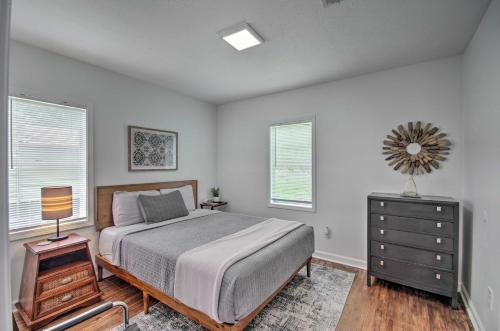 a bedroom with a bed and a dresser and two windows at Updated Jackson Home about 3 Mi to JSU Stadium! in Jackson