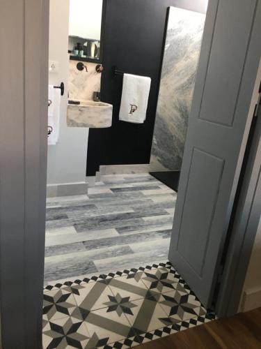 a bathroom with a black and white tile floor at Palacete Encanto Maior in Campo Maior