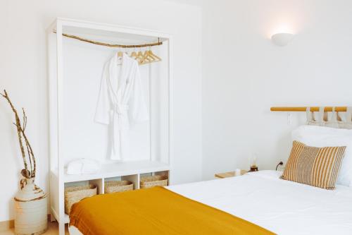 a bedroom with a white bed and a yellow blanket at Oliveiras Village — Agroturismo in Amarante