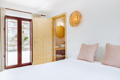 a bedroom with a white bed and a window at Oliveiras Village — Agroturismo in Amarante