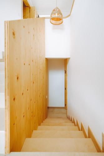 a hallway with a wood paneled wall and a light fixture at Oliveiras Village — Agroturismo in Amarante