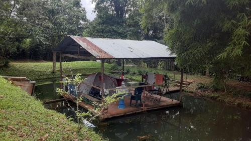 a boat with a roof in the water at LA CASA DEL BOSQUE Via SALADITO in La Elvira