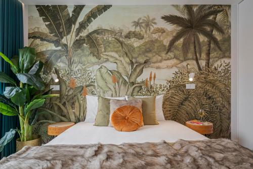 a bedroom with a wall mural of palm trees at Cine Park Residences by An Island Apart in Funchal