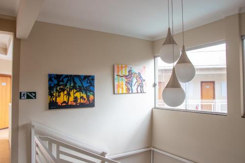 a hallway with three paintings on the wall at Casagrande Olímpia Hotel in Olímpia