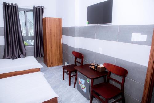 a room with two chairs and a table and a tv at Trường Phúc Vinh Hotel in Phan Thiet