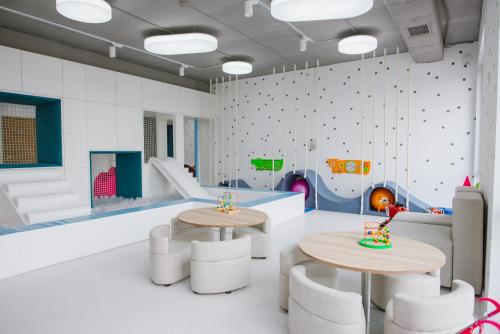 a room with two tables and a climbing wall at Hotel Zefir in Drohobytsch