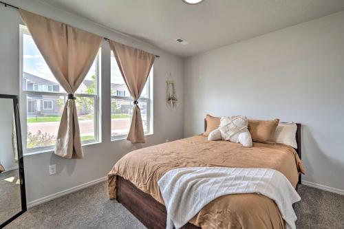 ein Schlafzimmer mit einem Bett und zwei Fenstern in der Unterkunft Cozy Caldwell Abode with Hot Tub about 3 Mi to Dtwn in Caldwell