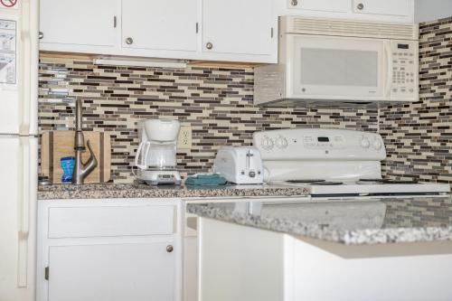 a kitchen with white cabinets and white appliances at Stroll to Slopes, Village Area, Ski in-out MtLodge 219 in Snowshoe