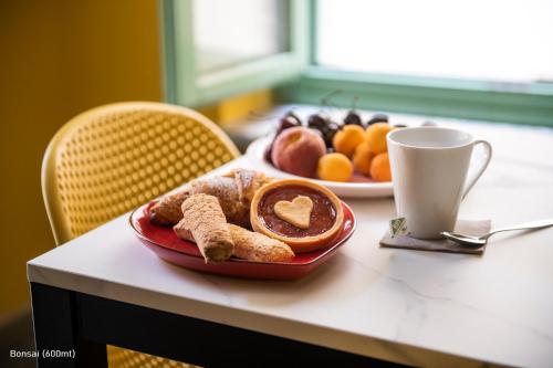 a plate of pastries on a table with a plate of fruit at San Francesco Guest House in Savigliano