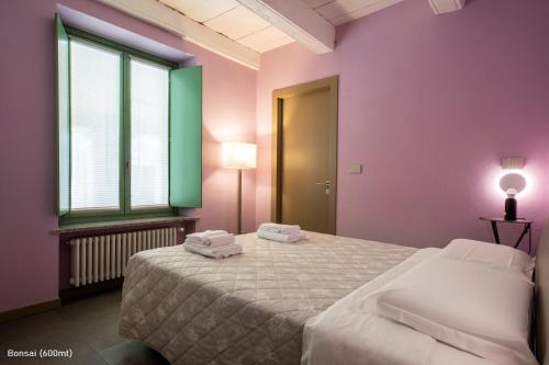 a bedroom with a bed with two towels on it at San Francesco Guest House in Savigliano