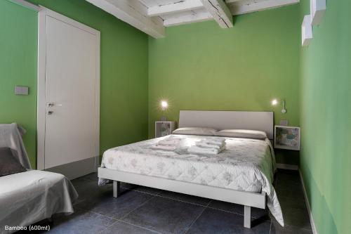 a bedroom with a white bed in a green wall at San Francesco Guest House in Savigliano
