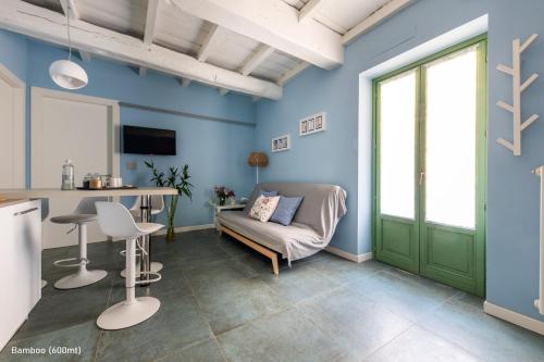 a living room with blue walls and a green door at San Francesco Guest House in Savigliano