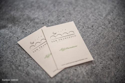 two white cards sitting on top of a table at San Francesco Guest House in Savigliano