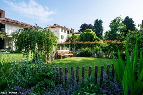 a garden with a bench and a fence at San Francesco Guest House in Savigliano