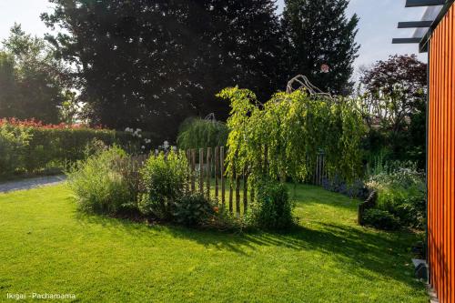 a garden with a fence and some bushes at San Francesco Guest House in Savigliano