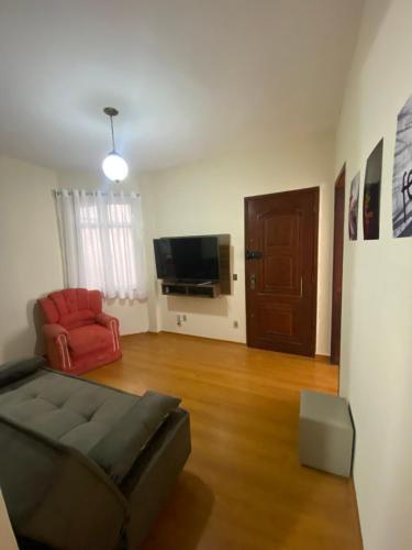 a living room with a couch and a television at Apto com garagem no centro de Nova Friburgo in Nova Friburgo