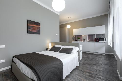 a bedroom with a large bed and a kitchen at Studio Inn De Angeli in Milan