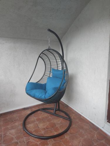 a swing chair with blue pillows in a room at Casa Mi&Ra in Lepşa