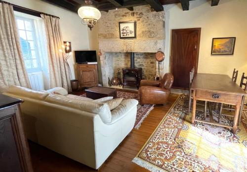 a living room with a couch and a fireplace at La Petite Maison in Beynac-et-Cazenac