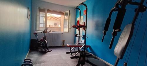una habitación con varios equipos de ejercicio en una habitación con ventana en Studio atypique dans bel immeuble de 1820, en Fumel