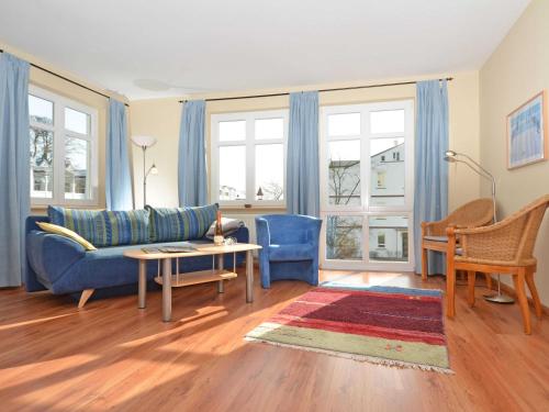 ein Wohnzimmer mit einem blauen Sofa und einem Tisch in der Unterkunft Villa Seerose - Appartement 05 in Ostseebad Sellin