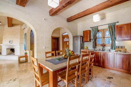 a kitchen with a table and chairs in a room at The Hamlet 3 Holiday Home in Għasri