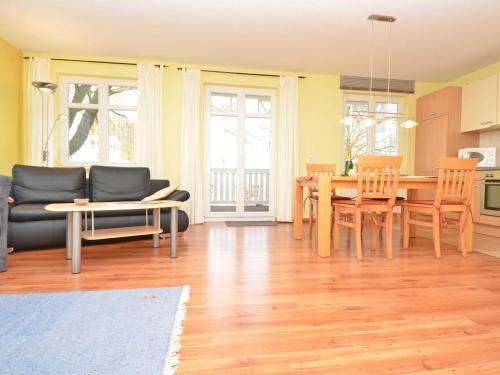ein Wohnzimmer mit einem Tisch, Stühlen und einem Sofa in der Unterkunft Villa Seerose - Appartement 02 in Ostseebad Sellin