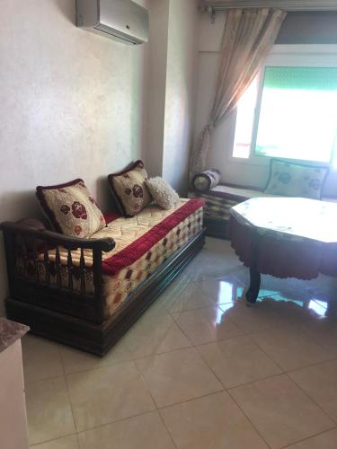een woonkamer met een bank en een raam bij 2 slaapkamers appartement zwembad in Tanger