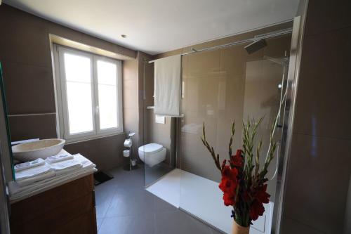 a bathroom with a sink and a toilet and a window at Chez Gilles hôtel resto bar SA in La Chaux-de-Fonds