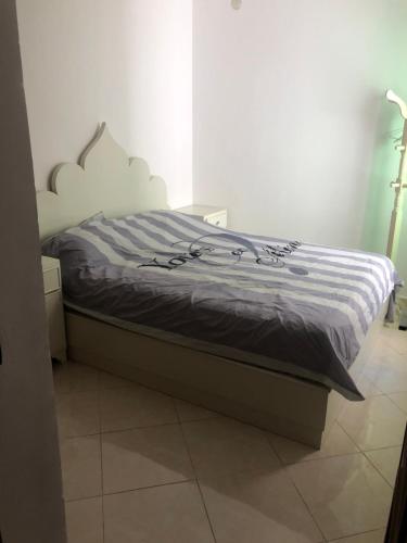 een bed in een kamer met bij 2 slaapkamers appartement zwembad in Tanger