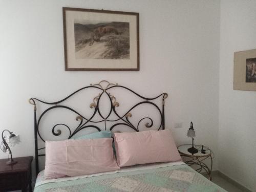 1 dormitorio con 1 cama con almohadas rosas en La Corte di Paola 1 e 2 en Génova