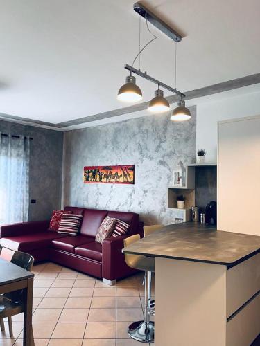 un soggiorno con divano rosso e una cucina di CASA MIA: appartamento con ogni comfort a Rodengo Saiano