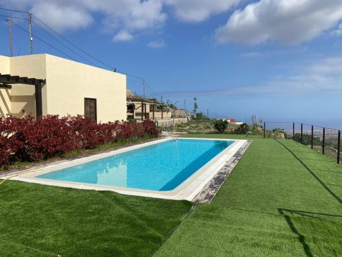 una piscina frente a una casa con el océano en Country house with shared pool and views, en Sabina Alta