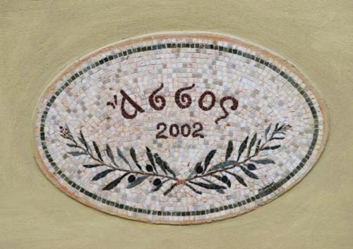 a mosaic plate with a plant on a wall at Roi Boutique Suites in Asos