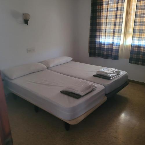 two twin beds in a room with a window at Apartamento centro de peñíscola CASA KIKO in Peniscola