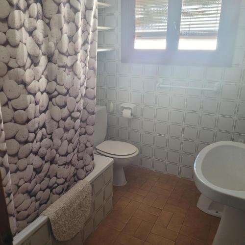 y baño con aseo y cortina de ducha. en Apartamento centro de peñíscola CASA KIKO en Peñíscola
