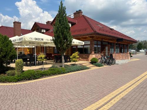 a building with a tree in front of it at Perła Dunajca Zakliczyn in Zakliczyn