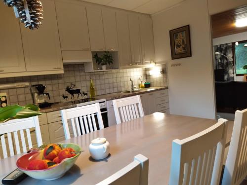 a kitchen with a table with a bowl of fruit on it at Holiday House Mäntyniemi in Hossa