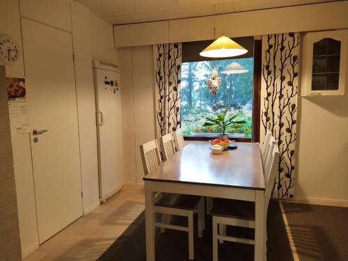 a kitchen with a table and chairs and a window at Holiday House Mäntyniemi in Hossa
