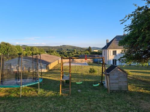 a backyard with a playground with a swing set at Maison de maître à 2 pas du lac des Settons in Montsauche