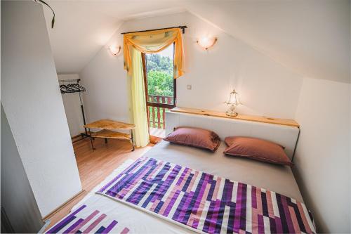 a bed with two pillows in a room with a window at Holiday Home Vesna with Sauna in Brežice