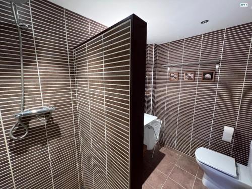 托羅埃利亞－德蒙特格里的住宿－MP - Dos en uno，浴室设有卫生间和铺有木质瓷砖的淋浴。