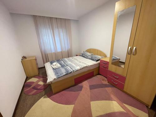 - une petite chambre avec un lit et un miroir dans l'établissement Apartament Retreat, à Drăgăşani