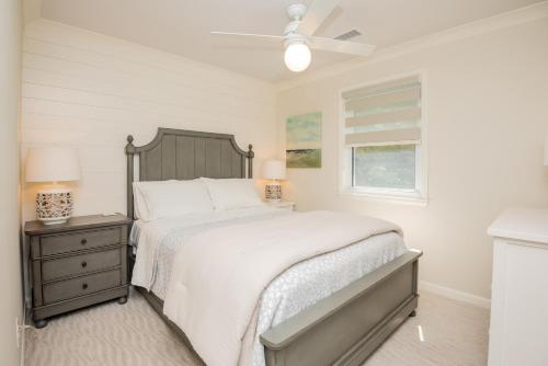 a white bedroom with a bed and a window at Wingspan by Oak Island Accommodations in Oak Island