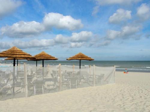a group of chairs and umbrellas on a beach at gîte Artbnb in Armbouts-Cappel