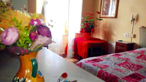 a room with a table with a vase of flowers at La Lilla in Siena