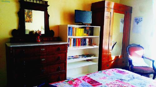 a bedroom with a dresser and a dresser with a mirror and a bed at La Lilla in Siena