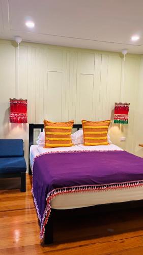 a bedroom with a large bed with a purple blanket at Baan Bua Cottage SHA EXTRA PLUS B5510 in Ko Kood