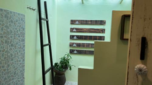 a room with a staircase with books and a plant at Baan Bua Cottage SHA EXTRA PLUS B5510 in Ko Kood