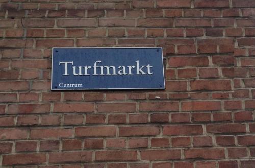 
a brick building with a sign on the side of it at Turfhuys aan het Spaarne in Haarlem
